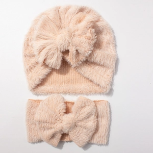 Detail of soft plush baby hat and headband set with large bows in peach pink color