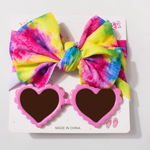 Détail du bandeau arc-en-ciel pour bébé et lunettes de soleil roses en forme de cœur