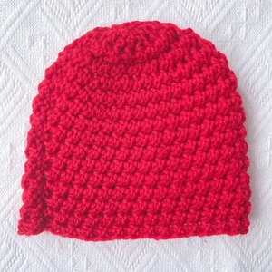 Detailed view of handmade chunky red knit baby beanie with textured crochet pattern