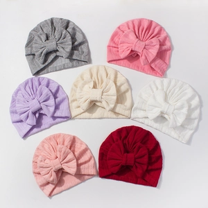 Détail de bonnets turban bébé en jacquard élastique avec grands nœuds en sept couleurs