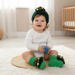 Detail of baby Christmas knit set with green tree hat and matching pompom socks