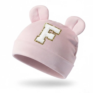 Close-up of pink modal baby hat featuring cute round ears and white letter F patch detail