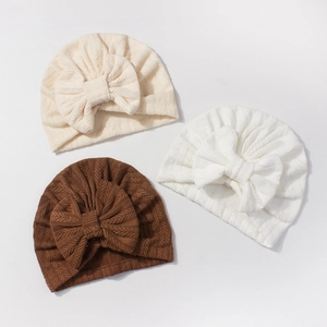 Détails de la maille côtelée et des grands nœuds sur trois turbans pour bébés colorés