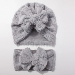 Detail of baby plush grey faux fur knotted beanie hat and matching large bow headband set