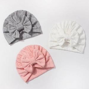 Détails de la texture tricotée douce et des grands nœuds sur les turbans pour bébés