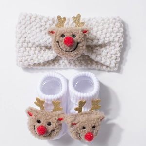 Detail of baby knitted headband and socks set featuring plush Christmas reindeer decor