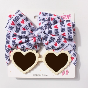 Détail de lunettes coeur crème et bandeau avec nœud MAMA'S GIRL pour bébés filles