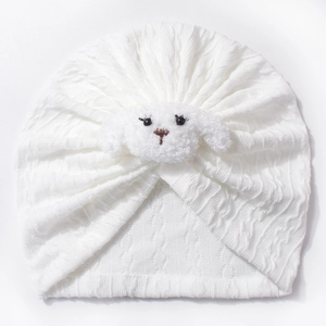 Detail of white rib-knit baby turban hat with a 3D plush animal puppy decoration