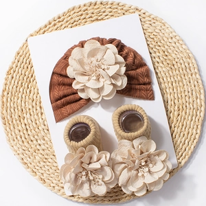 Detailed view of ribbed baby headband and socks with large floral fabric embellishments