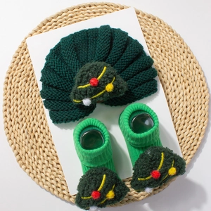Detailed view of dark green knitted baby hat and socks set with 3D crochet Christmas trees