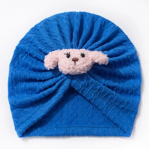 Detailed knit texture of royal blue baby turban hat with plush puppy dog ornament