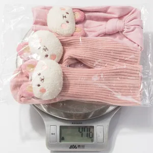 Pink infant bow headband and knit socks set with teddy bear patches weighing 47.6g
