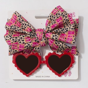 Détail de lunettes de soleil cœur rouge et bandeau léopard sur carte support