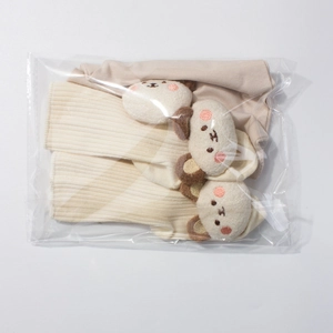 Detailed view of baby socks with 3D plush bear head in beige and pink modal fabric