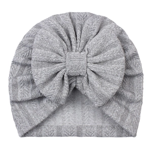 Gros plan du bonnet turban pour bébé gris avec texture tricotée et grand nœud