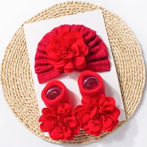 Detail of red infant cap with pleated flower and matching floral socks set
