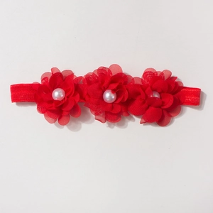 Détail du bandeau bébé avec fleurs en mousseline rouge et perles blanches centrales