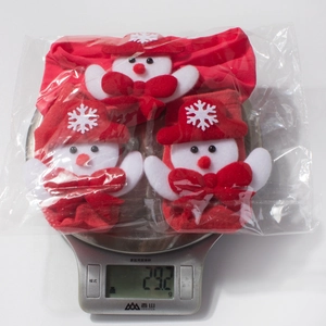Detail shot of newborn Christmas socks set on weight scale showing 29.2g mass