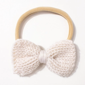 Close-up of cream knit bow on elastic nylon baby headband with detailed woven texture
