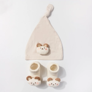 Detailed view of modal baby hat and socks set with 3D teddy bear plush decorations