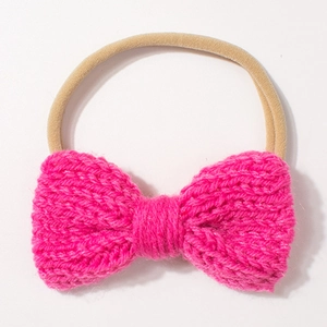 Detailed close-up of rose pink knitted bow headband with elastic seamless nylon band