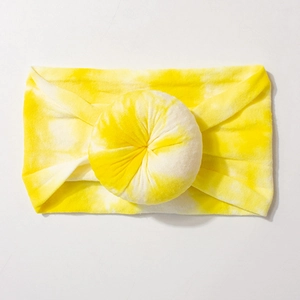Detail of baby nylon headband featuring a large yellow and white tie-dye donut flower ball