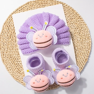 Detail of purple knit baby set featuring a 3D cartoon bee design on hat and socks