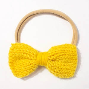 Close-up of bright yellow knitted bow headband with clear soft yarn textures