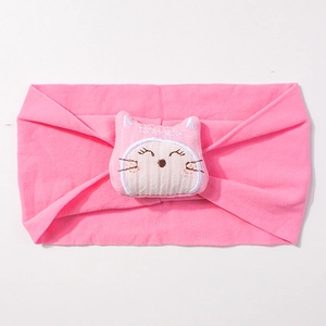 Détail du bandeau rose en nylon pour bébé avec une poupée chat en peluche et broderie