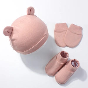 Detail view of cotton newborn set with bear ear hat, mittens and booties in dusty pink