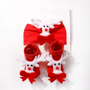 Close-up of red Christmas baby headband and socks set with 3D reindeer and bow details