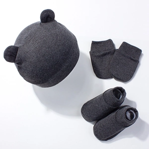 Detailed close-up of dark grey knitted baby set with bear ear hat, mittens, and booties