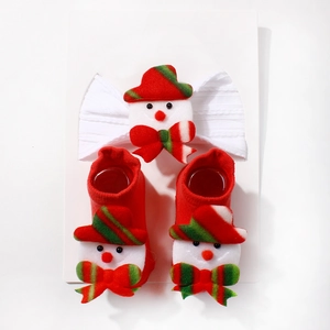 Detailed view of baby Christmas set featuring snowman headband and knit socks on card