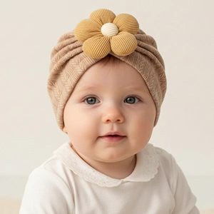 Detailed knit texture and yellow flower accent on a soft beige baby turban hat