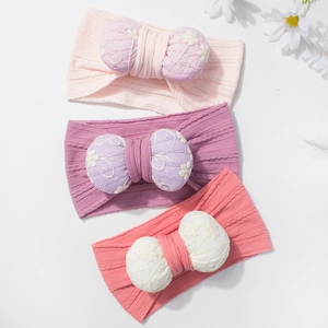 Three elastic baby headbands with large embroidered floral bows in pink and purple colors