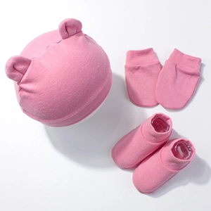 Detail view of baby pink cotton hat with bear ears, matching mittens and socks set