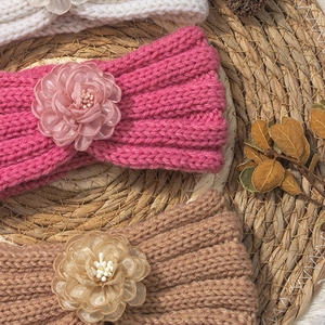 Dettaglio di fasce per neonati in maglia con fiori di chiffon e trama in lana calda