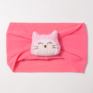 Gros plan du bandeau bébé élastique rose avec décoration de poupée chat brodée mignonne