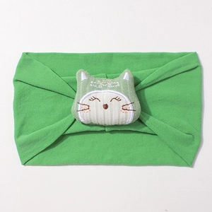 Bandeau bébé en nylon vert avec petit chaton en peluche sur un fond blanc neutre