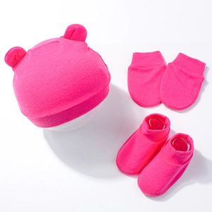 Close-up of pink newborn baby set including bear ear hat, mittens, and socks