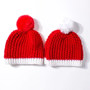 Christmas knit beanies for baby and parent with festive red and white pom poms