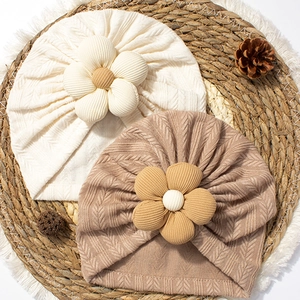 Soft bohemian baby turban hat with decorative five-petal flowers in cream and khaki