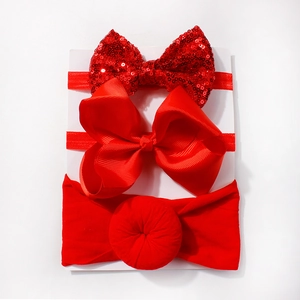 Detailed view of red baby headband set with sequins, grosgrain bow, and soft fabric donut