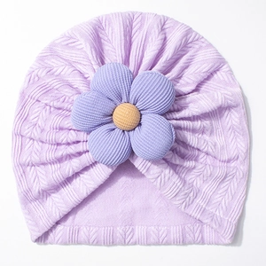 Detailed close-up of light purple baby knit hat with thick cable knit and flower detail