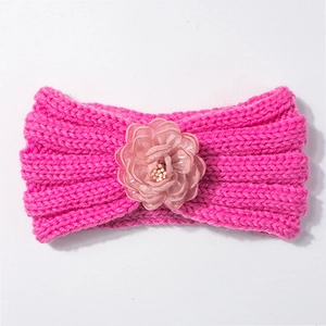 Vista dettagliata della fascia per neonati in maglia rosso rosa con decoro floreale 3D