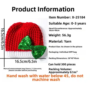 Detail view of red baby Christmas hat with oversized green sequin bow and size dimensions