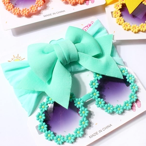 Baby mint green bow headband and sunflower petal sunglasses set on display card