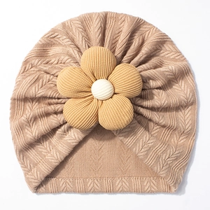Close-up of cable knit baby turban hat with a large decorative corduroy flower