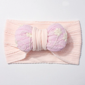 Detail of baby headband with jacquard stretch fabric and embroidered cotton bow