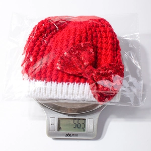 Detailed view of lightweight Christmas baby hat with sequined bow weighing 56.3 grams